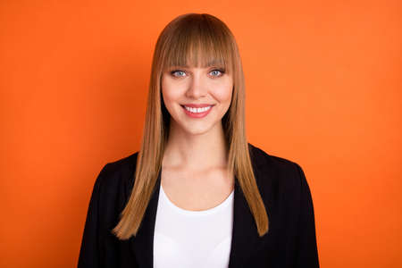 Photo of optimistic nice blond hair lady wear black jacket isolated on bright orange color backgroundの写真素材