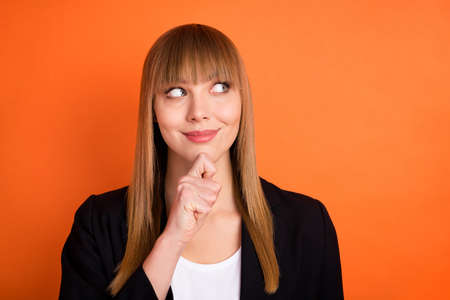 Photo of optimistic nice blond hair lady look empty space wear black jacket isolated on bright orange color backgroundの写真素材
