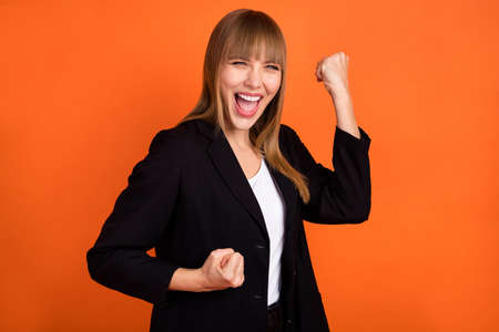 Profile photo of hooray nice blond hair lady hands fists wear black jacket isolated on bright orange color backgroundの写真素材