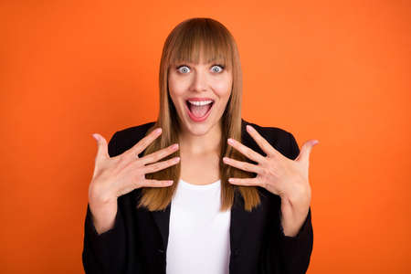 Photo of impressed nice blond hair lady hands wear black jacket isolated on bright orange color backgroundの写真素材