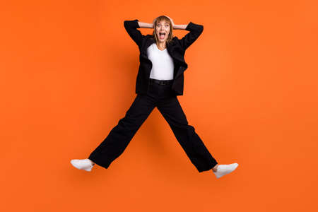 Full size photo of young happy excited crazy amazed crazy girl jumping see huge sale discount isolated on orange color backgroundの写真素材
