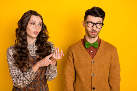 Portrait of nice couple girl saying pretense to guy bad mood psychology isolated over bright yellow color backgroundの写真素材