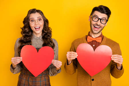 Portrait of nice comic cheerful friends friendship trendy couple holding heart shape having fun isolated on bright yellow color backgroundの写真素材