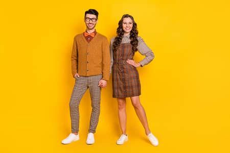 Full length body size view of attractive confident cheerful couple holding hand meet first date isolated on bright yellow color backgroundの写真素材