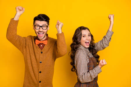 Photo of happy charming triumphant man and woman success lucky winner isolated on yellow color backgroundの写真素材