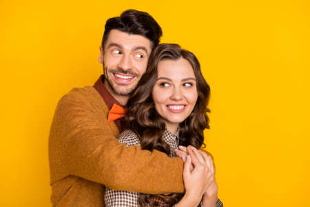 Photo of happy boyfriend and girlfriend hug look each other smile isolated on bright yellow color backgroundの写真素材