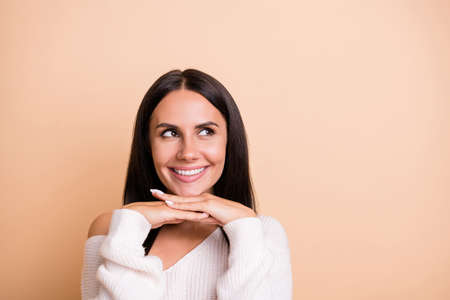Photo of young girl happy positive smile dream dreamy look empty space isolated over beige color backgroundの写真素材