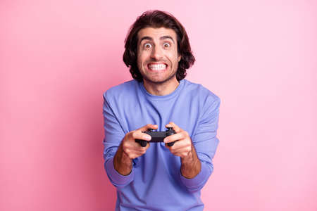 Photo of interested curly hairdo guy hold having fun wear purple sweater isolated on pastel pink color backgroundの写真素材