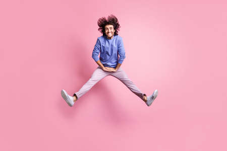 Full size photo of young attractive cheerful positive smiling happy man jump fly isolated on pink color backgroundの写真素材