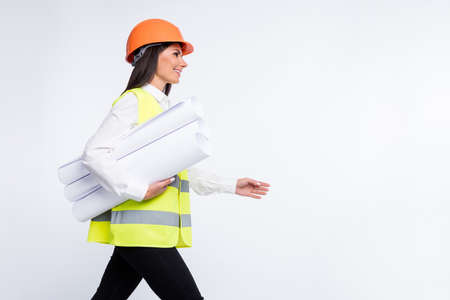 Profile photo of lady hold rolls paper walk look empty space wear helmet shirt vest isolated white color backgroundの写真素材