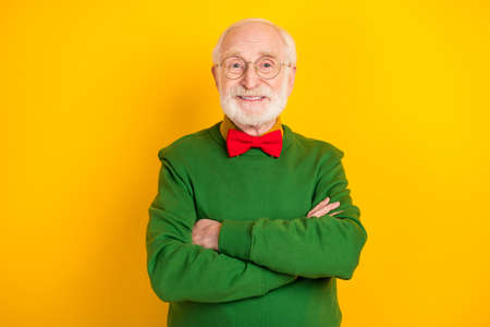 Photo of thoughtful confident mature man dressed pullover bow tie glasses arms crossed isolated...