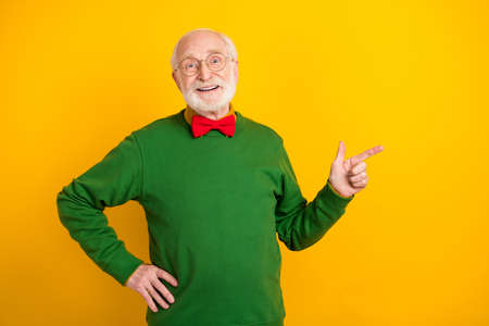 Photo of cute charming age gentleman wear sweater bowtie spectacles pointing finger empty space...