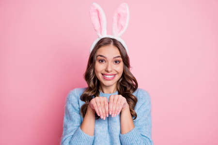 Photo of funny childish lady play rabbit hands paws wear bunny ears headband blue sweater isolated pink backgroundの写真素材