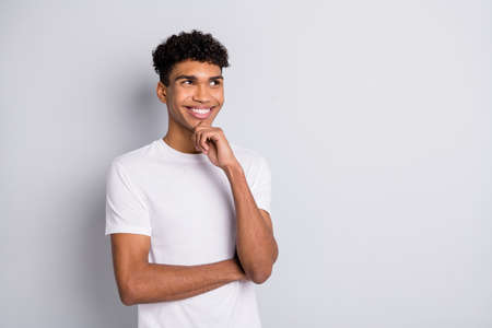 Photo of minded thoughtful guy finger chin look empty space wear white t-shirt isolated grey backgroundの写真素材