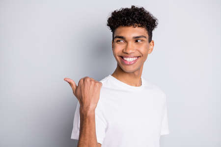 Photo of promoter guy direct thumb look empty space wear white t-shirt isolated grey backgroundの写真素材