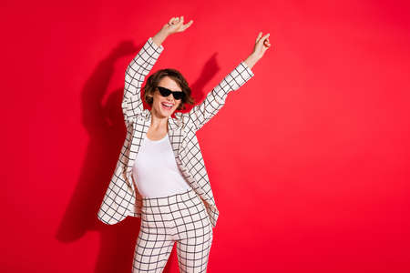 Photo of young excited girl happy positive smile enjoy have fun dance disco isolated over red color backgroundの写真素材