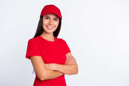 Photo of young smiling lovely confident delivery woman with folded hands professional isolated on grey color backgroundの写真素材