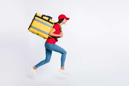 Full size profile side photo of young attractive positive delivery girl running isolated on grey color backgroundの写真素材