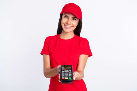 Photo of young happy cheerful delivery girl give you terminal cashless payment isolated on grey color backgroundの写真素材