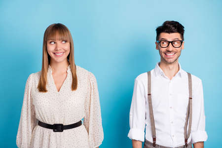 Photo of funny pretty young couple wear white outfit looking each other isolated blue color backgroundの写真素材