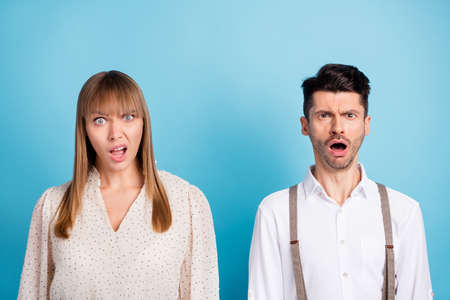 Photo of unsure upset young couple wear white outfit open mouth isolated blue color backgroundの写真素材