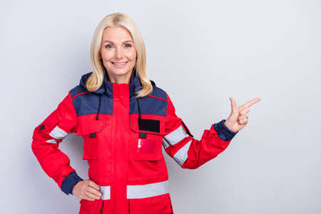 Photo of charming candid person put hand on waist indicate finger empty space isolated on grey color backgroundの写真素材