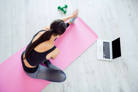 Top above high angle view photo of young woman practicing stretching pilates fitness laptop gym homeの写真素材