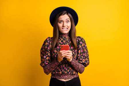 Portrait of attractive lady bite lip panic headwear retro clothing isolated on yellow color...