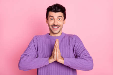 Photo of impressed funny young man dressed purple pullover arms together ask buy new gadget isolated pink color backgroundの写真素材