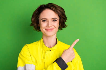 Photo of young woman firefighter happy positive smile point finger empty space advice suggest...