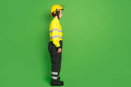 Full length photo of confident pretty firewoman dressed yellow uniform helmet looking empty space...