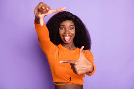 Portrait of attractive crazy cheerful wavy-haired girl showing frame grimacing isolated over purple violet pastel color backgroundの写真素材
