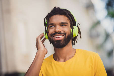 Photo portrait of guy listening music in earphones enjoying song smiling happy wearing casual outfit