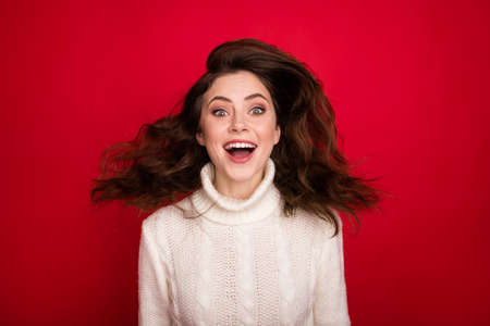 Portrait of attractive cheerful amazed girl having fun jumping great news isolated over bright red color backgroundの写真素材