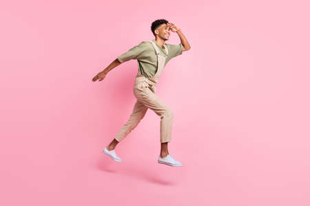 Profile photo of guy jump palm head look empty space run wear beige overall footwear isolated pink...