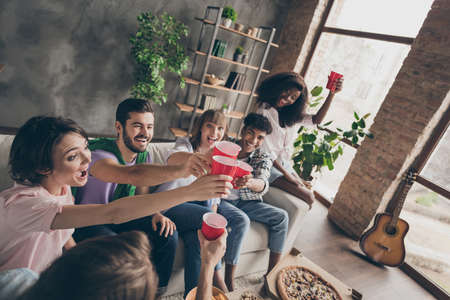 Portrait of attractive cheerful best friends spending time having fun drinking lager in house brick loft style flat campus dormitory indoorsの写真素材