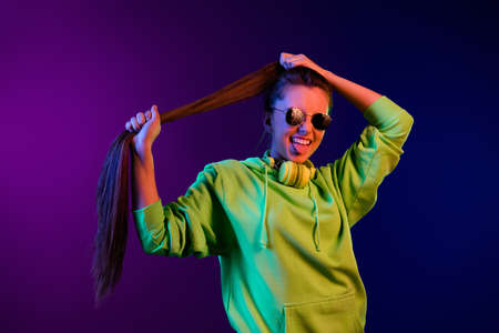 Photo of crazy funky young woman hold hand hair tail wear sunglass cool stick out tongue isolated on...