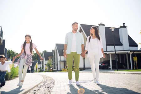 Full length body size view of four careful cheery family walking playing enjoying leisure sunny day having fun time in cottage town outdoorの写真素材