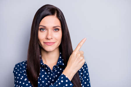 Portrait of optimistic good brunette girl point empty space wear blue blouse isolated on grey color...