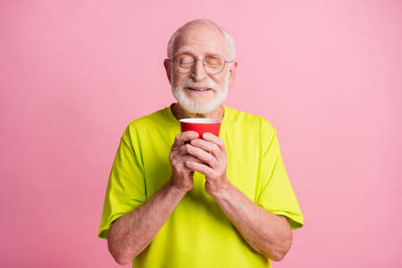 Portrait of funky pensioner hold cup smell coffee wear spectacles lime color t-shirt isolated on...