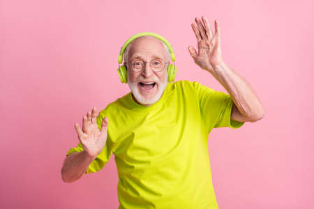 Photo of crazy optimistic old man listen music dance arms wear headphones spectacles lime color...