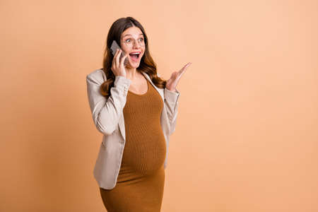 Photo of sweet pretty woman expecting child wear jacket arm belly talking modern device empty space...