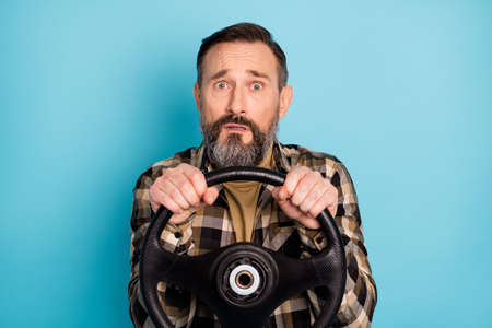 Photo portrait of stressed worried man driving car trying to get license accident isolated on bright blue color backgroundの写真素材