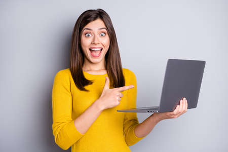 Photo of hooray brunette nice lady hold point laptop wear eyewear yellow sweater isolated on grey color backgroundの写真素材