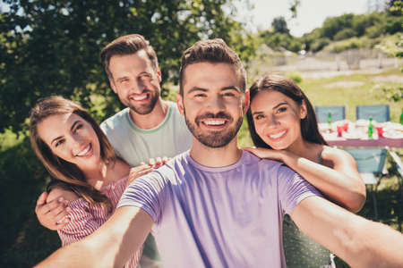 Photo of company four members smiling recording selfie video camera outside outdoors garden park...