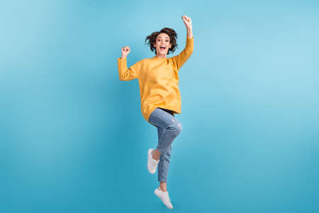 Full length body photo of cheerful pretty girl jumping high gesturing like winner laughing smiling...