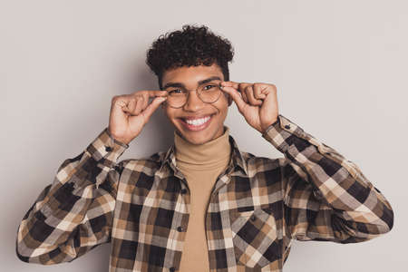 Photo of guy hold eyeglasses toothy shiny smile look camera wear plaid shirt turtleneck isolated grey color backgroundの写真素材