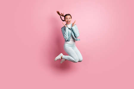 Full length photo portrait of amazed woman jumping up isolated on pastel pink colored background
