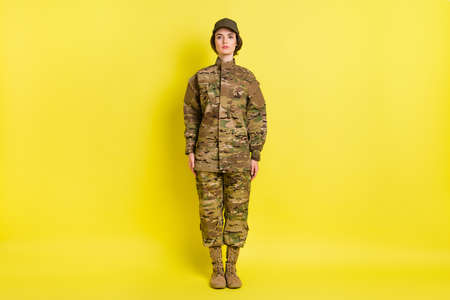 Full size portrait of focused charming person standing look camera wear hat isolated on yellow color backgroundの写真素材