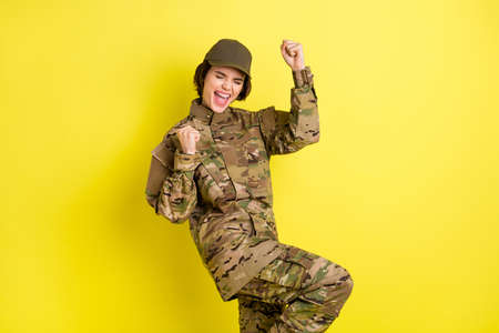 Portrait of delighted positive lady closed eyes fists knee up open mouth shout yes isolated on...